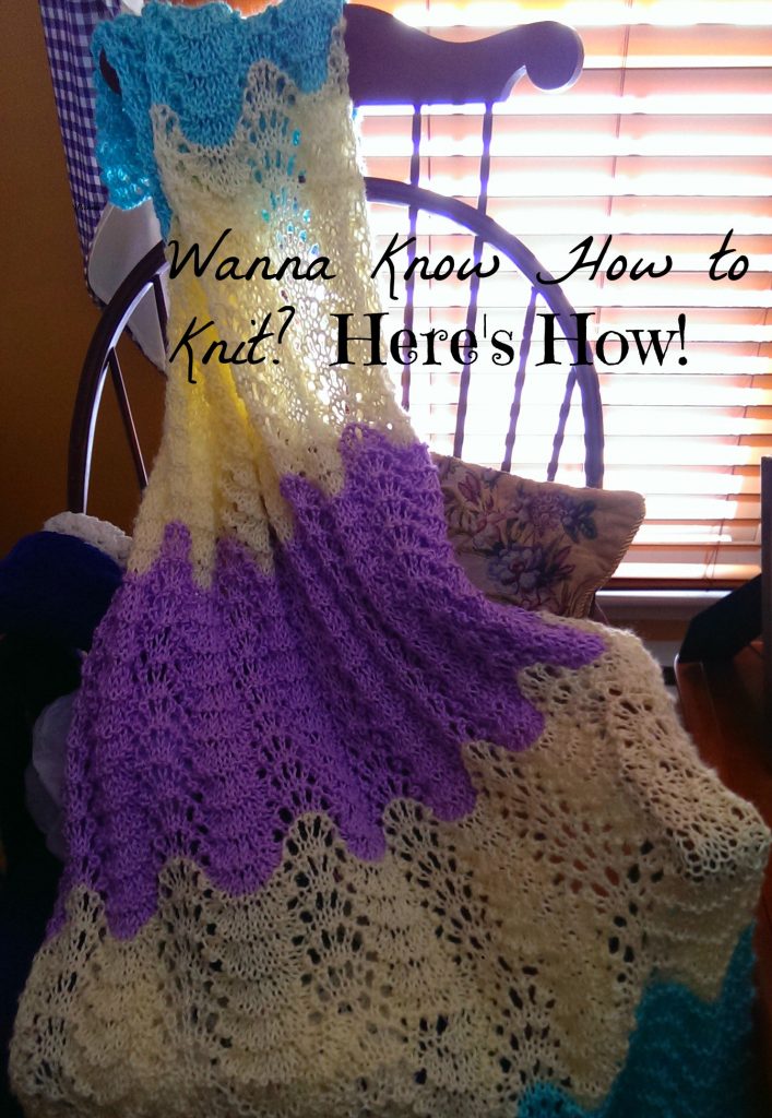 A beautiful feather-and-fan afghan knit in off-white and lavendar colors.