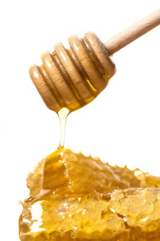 Honey dipper above honeycomb