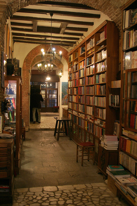 A hall in an old library and shelves filled with books